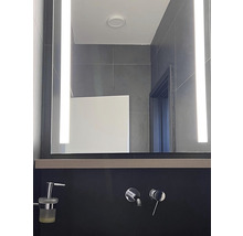 Modernes Badezimmer mit beleuchtetem Spiegel und Armaturen