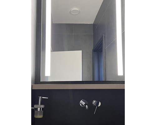 Modernes Badezimmer mit beleuchtetem Spiegel und Armaturen