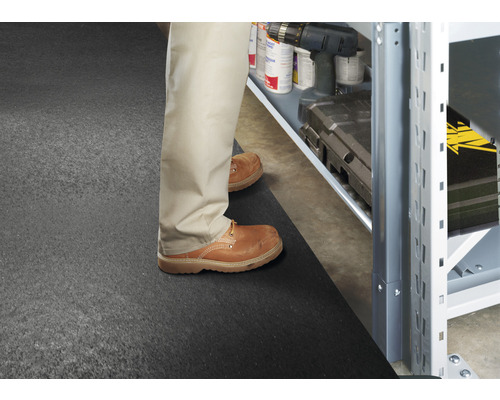 Szene mit einer Person, die vor einem Regal auf einer Bodenmatte steht