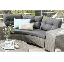Gartenlounge-Set mit Rattanoberfläche, grauen Polstern und Kissen auf einer Terrasse