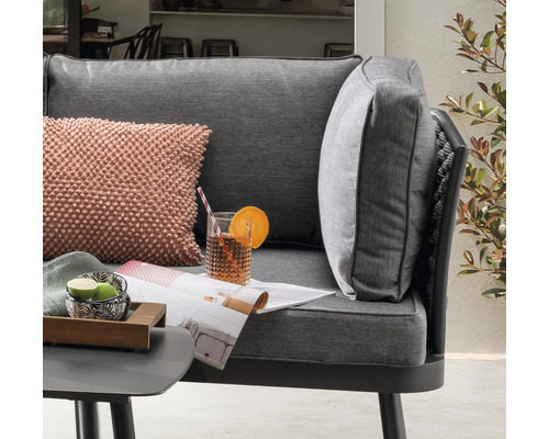 Detailaufnahme eines Gartensessels mit Kissen und Getränk