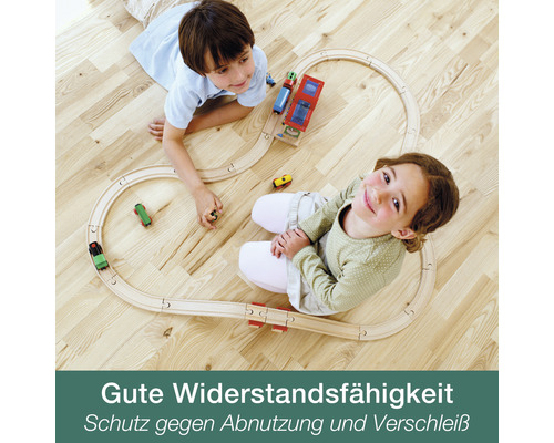 Zwei Kinder spielen mit einer Holzeisenbahn auf einem Holzboden
