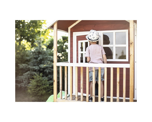 Kind auf der Veranda eines Spielhauses im Garten.