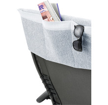 Detailansicht einer Sitzgelegenheit mit aufgesetzter Tasche für Zeitschriften und einer Brille