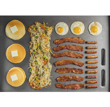 Pfannkuchen mit Butter, Kartoffelpuffer, Spiegeleier, Speck und Würstchen auf einem Backblech