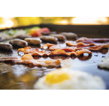 Speck, Würstchen und Spiegelei auf einer Grillplatte