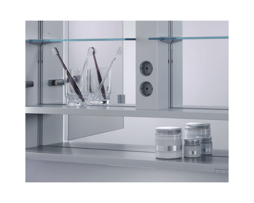 Badezimmerszene mit Spiegelschrank, Steckdosen, Gläsern, Zahnbürsten und Behältern auf den Regalen