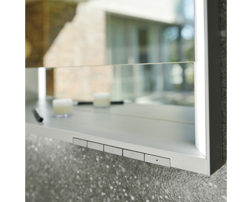 Detailaufnahme eines Spiegelschranks mit Ablagefläche und Bedienelementen.