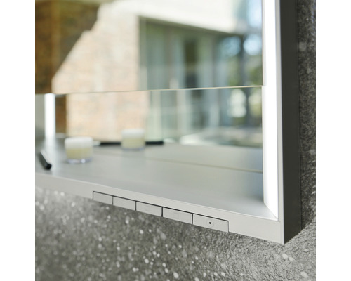 Nahaufnahme eines Spiegelschranks mit Ablagefläche und Bedienelementen