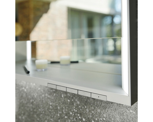 Detailansicht eines Spiegelschranks mit Schaltern und Ablagefläche im Badezimmer