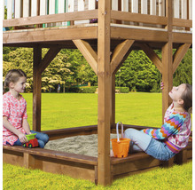 Spielturm mit Sandkasten und spielenden Kindern im Garten.