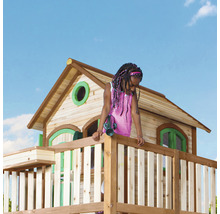 Mädchen auf einem Holzspielturm mit Haus