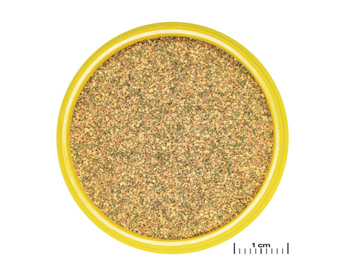 Blick von oben auf Vogelsand in einer gelben Schale