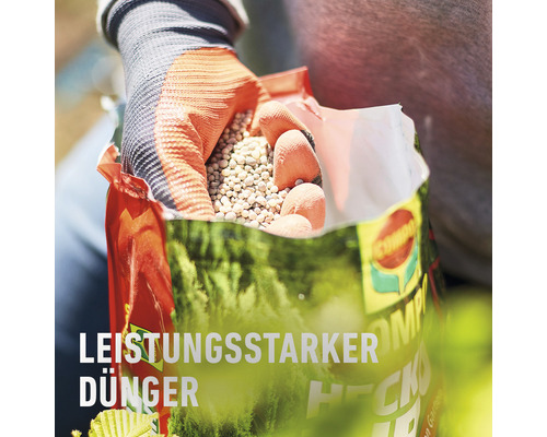 Person hält eine offene Tüte mit Dünger in der Hand