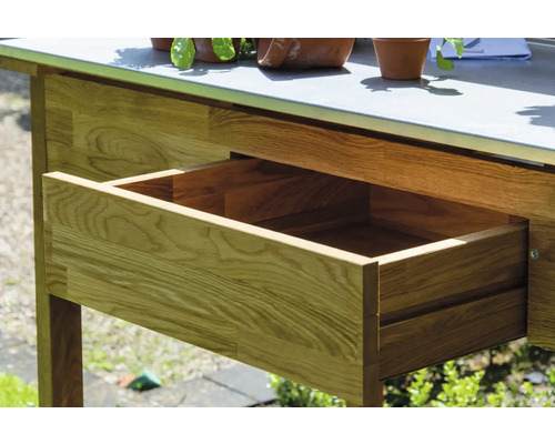 Detailaufnahme eines Gartentisches aus Holz mit offener Schublade