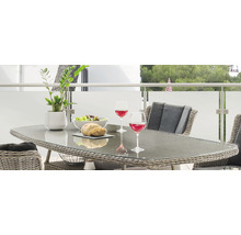 Gedeckter Gartentisch mit Gläsern, Salatschüssel und Brot auf einem Balkon