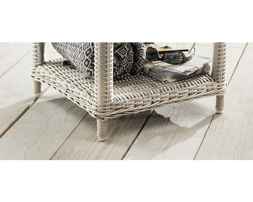 Nahaufnahme eines Korbtisches mit Ablagefläche für Zeitschriften, eine Tasche und eine Sonnenbrille