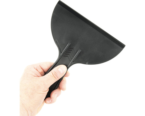 Schwarzer Kunststoffspachtel wird von einer Hand gehalten.