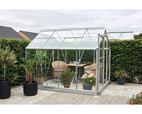 Gewächshaus mit Tisch und Stühlen im Garten