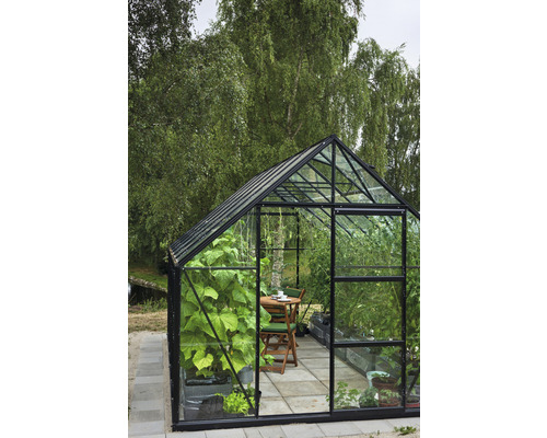 Gewächshaus mit Pflanzen und Tischgruppe im Garten