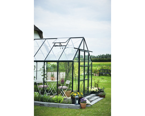 Gewächshaus mit Tisch und Stühlen im Garten