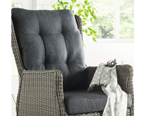 Detailaufnahme eines Rattansessels mit grauen Polsterkissen