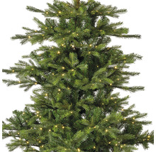 Detailansicht eines grünen, künstlichen Weihnachtsbaums mit Beleuchtung