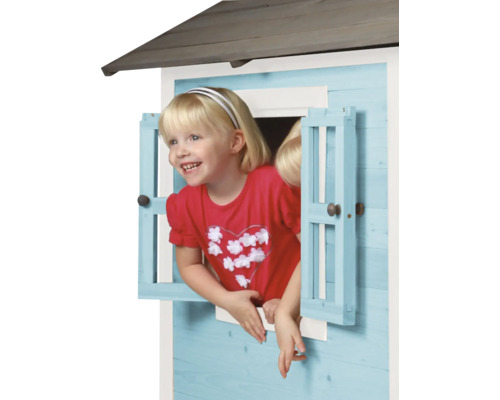 Mädchen schaut aus dem Fenster eines Kinderspielhauses aus Holz