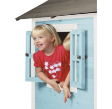 Mädchen schaut aus Fenster eines Spielhauses aus Holz