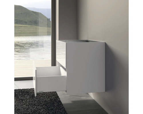 Weißer Waschbeckenunterschrank mit offener Schublade an einer Badezimmerwand