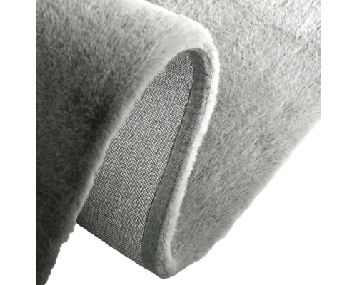 Detailansicht eines grauen Teppichs mit weicher Oberfläche und gewebter Rückseite