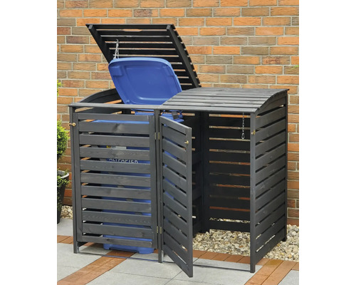 Mülltonnenbox für zwei Mülltonnen mit Lattenstruktur vor einer Ziegelwand