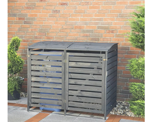 Doppel-Mülltonnenbox aus Holz mit Lattenmuster vor einer Ziegelmauer