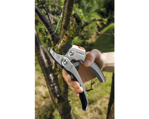 Gartenschere beim Schneiden eines Astes, Gardena Logo