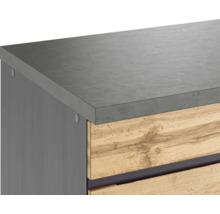 Detailaufnahme eines Badezimmerschranks mit grauer Arbeitsplatte und Holzschubladen