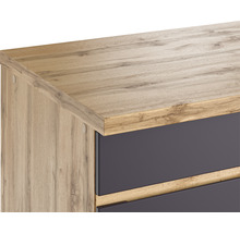 Detailansicht eines Schranks mit Holzoberfläche und dunklen Schubladen