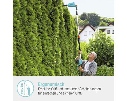 Mann schneidet Hecke mit einer elektrischen Heckenschere mit Teleskopstiel.