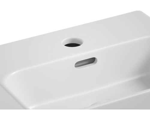 Detailansicht eines Waschbeckens mit Hahnloch und Überlauf