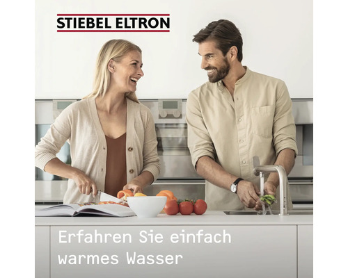 Frau schneidet Gemüse, Mann wäscht Gemüse unter Wasserhahn, Stiebel Eltron Logo