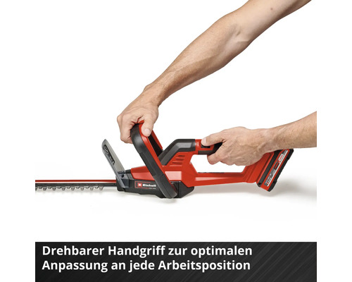 Person bedient eine rote Einhell Akku-Heckenschere mit drehbarem Griff.