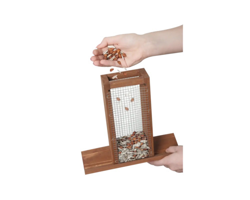 Befüllen einer Vogel-Futterstation mit Körnerfutter