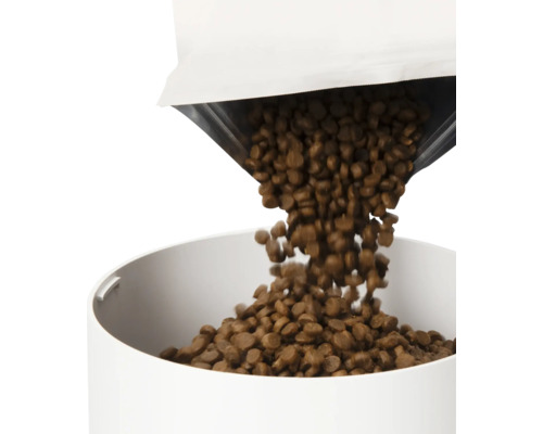 Tiernahrung wird in einen Futterautomaten gefüllt