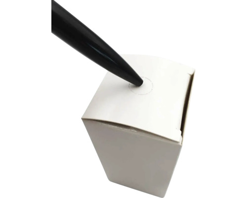Schwarzer Stift, der eine weiße Schachtel durchbohrt