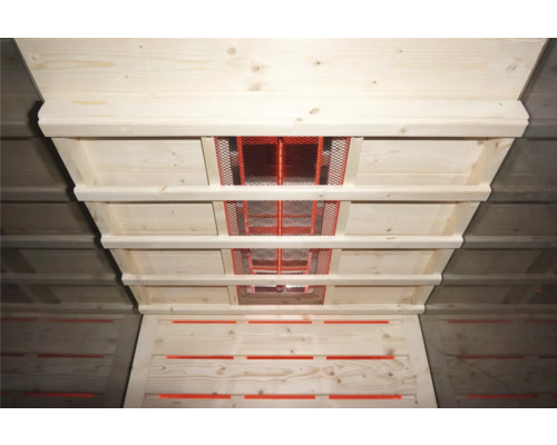 Blick in einen Dachstuhl mit Holzkonstruktion und Lüftungsgittern.