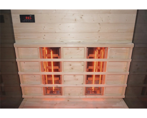 Innenansicht einer Sauna mit Infrarotstrahlern und Temperaturanzeige.