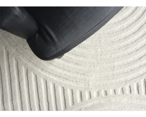 Detailaufnahme eines Teppichs mit geometrischem Muster und einem Möbelstück