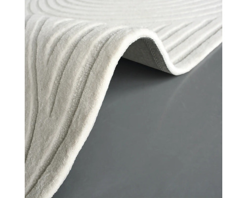 Detailansicht eines beigen Teppichs mit wellenförmigem Muster