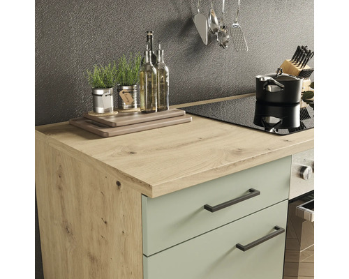 Küchenszene mit Arbeitsplatte, Spüle, Kochfeld, Topf und Küchenutensilien.