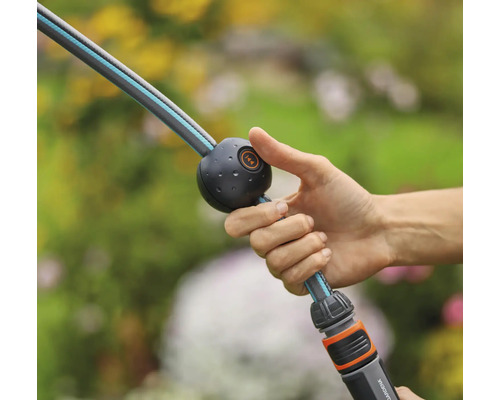 Eine Hand hält einen Gartenschlauch mit Wasserstopp-Funktion