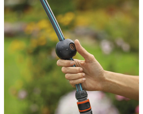 Hand hält einen flexiblen Gartenschlauch mit Kugelgelenk